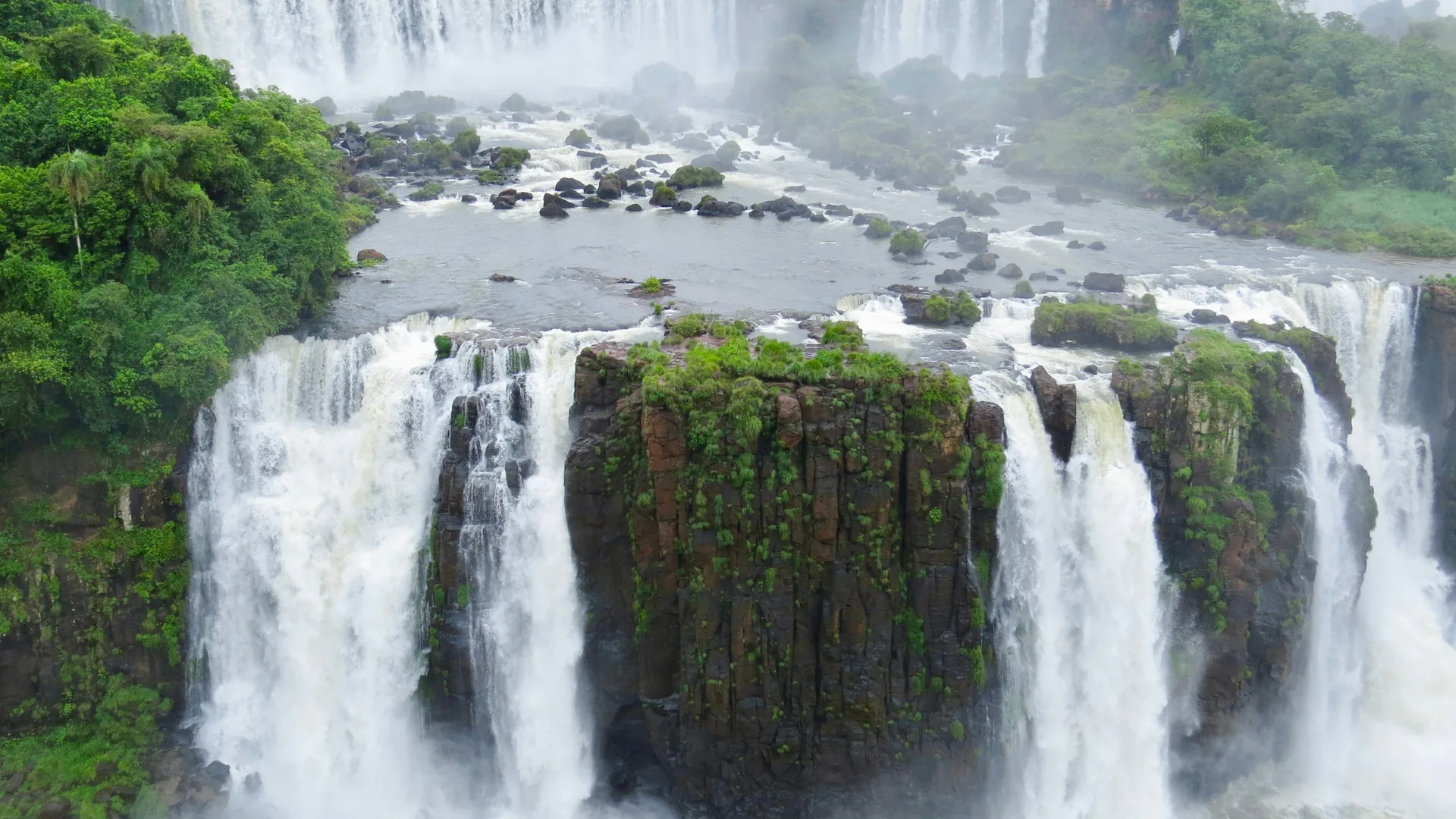 The Devil's Throat cataract at Iguazú Falls with rising mist and rainbows
